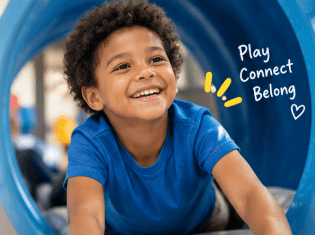 Children playing together in a calm, brightly lit indoor recreation space designed for sensory-friendly movement, exploration, and connection